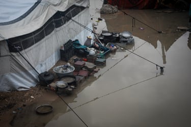 Belongings outside a tent in Gaza surrounded by floodwater