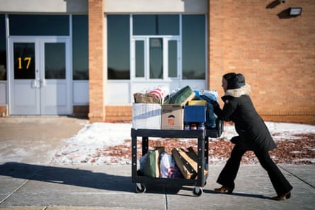 a woman pushes a cart stacked with school supplies outside
