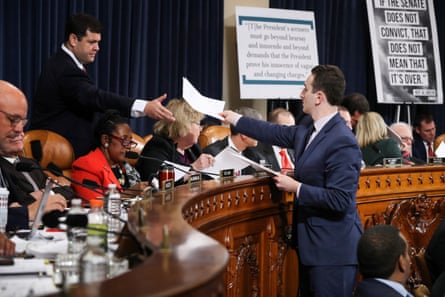 a man in a suit hands out sheets of paper