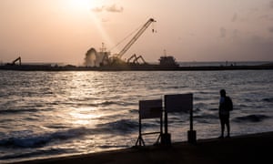 A man stands looking out over the construction site of Colombo International Financial City, Sri Lanka