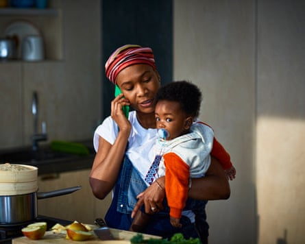 A woman speaking on the phone while holding a baby.