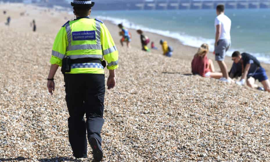 Police community support officer patrols the beach in Brighton