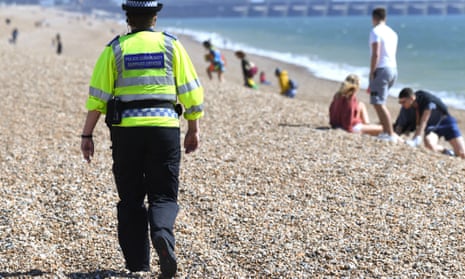 Police community support officer patrols the beach in Brighton