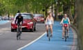 Two women ride bicycles in a cycle lane