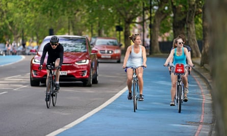 People ride bicycles in a cycle lane in London.