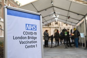 People queue at an NHS Covid-19 vaccination centre in London as cases of the virus continue to soar and the Government raises restrictions around the country.
