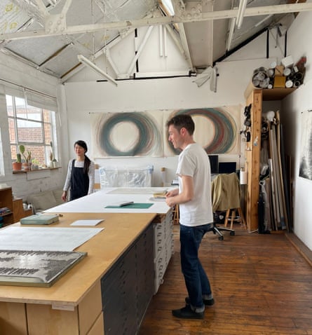 Two artists at a huge table in a loft space