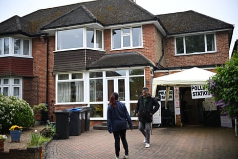 Voters at a polling station in Croydon, where a polling station has been set up at a garage inside a house.