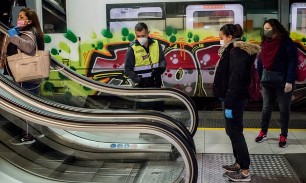 A security guard controls the distance between commuters on escalators at Catalunya station in Barcelona.