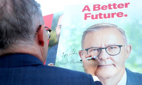 Anthony Albanese signs a campaign corflute with his face on it and the slogan ‘a better future’