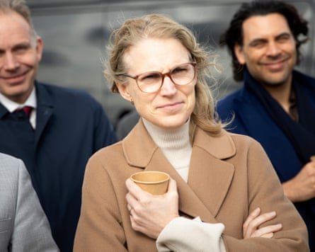 Elanor Boekholt-O’Sullivan holds a brown paper cup and looks slightly windswept as she looks off-camera