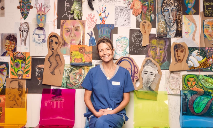 Dr Laura Marshall-Andrews in her Brighton surgery with lots of artwork on the wall behind her