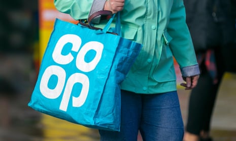 a woman carries  blue Co-op bag for life