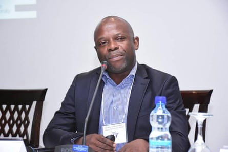Prof Pierre Akilimali, sitting at a table with a microphone on it.