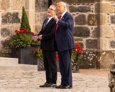 US President Donald Trump and British Prime Minister Keir Starmer (left) listen to a bagpipe band as they arrive at the Trump International Golf Links course in Aberdeen, Scotland on 28 July 2025.