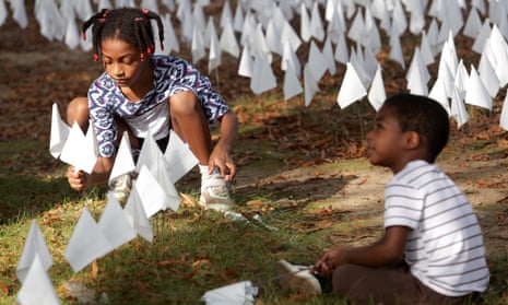 Hope Larkin plants flags with her brother Walter Larkin during a press preview of the public art project ‘IN AMERICA How could this happen …’ on the DC Armory Parade Ground in Washington DC.