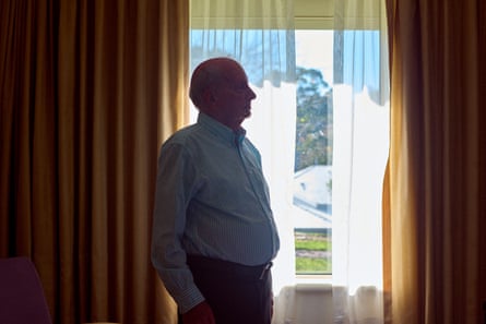 Andrew McKean in silhouetted in front of curtains by a window
