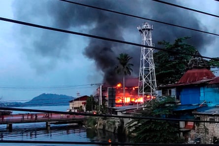 Smoke billows from a building after hundreds of demonstrators marched near Papua’s biggest city Jayapura.