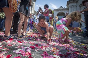Children and spectators collect petals from the road that Muhammad Ali’s funeral procession passed along