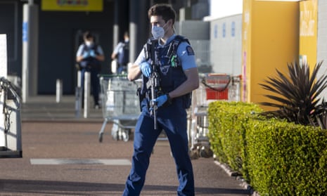 An armed police officer patrols outside the supermarket where an extremist stabbed several shoopers in Auckland, New Zealand. 