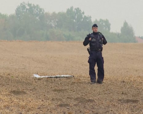 A Polish police officer stands near a unmanned aerial vehicle (UAV) fragment, after Russian drones violated Polish airspace during an attack on Ukraine and some were shot down by Poland, in Czesniki, Poland.
