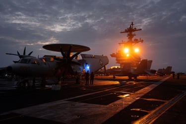 Sailors tend to a Grumman E-2 Hawkeye radar plane.