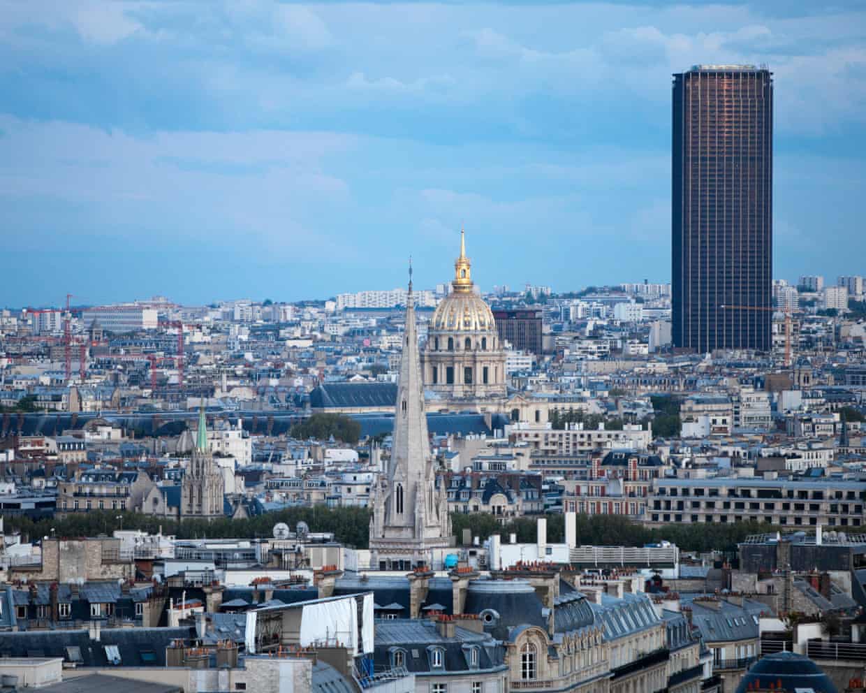 A tall, dark skyscraper stands out over Paris's other buildings
