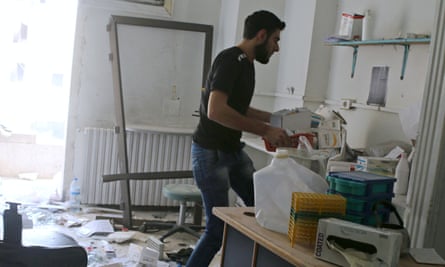 A man salvages medicine inside al-Quds hospital