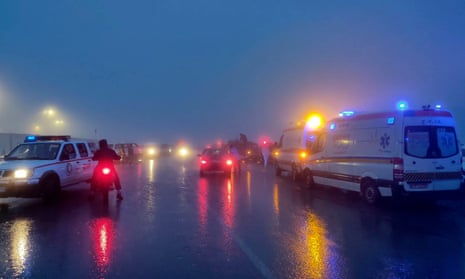 Rescue vehicles on a road in fog after dark