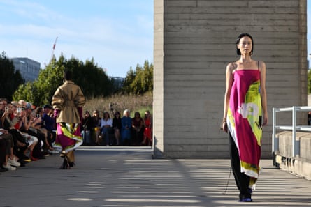 A model walks the runway in a hot pink, lime green and white dress