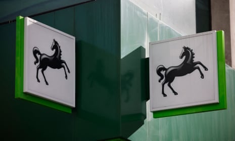 A logo is pictured on a sign outside a branch of a Lloyds Bank in London