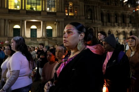 Supporters hold candles as they stand in silence during a vigil in honour of Kumanjayi Little Baby in Sydney