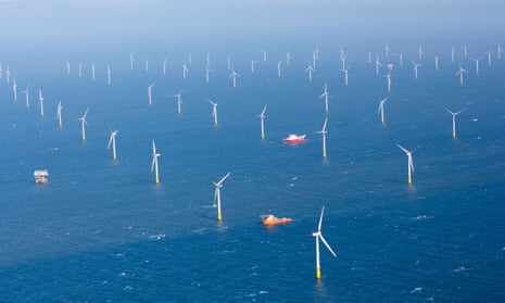 A wide shot of dozens of offshore wind turbines