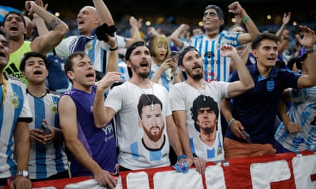 Identical twins wearing matching T-shirts of Messi and Maradona during the semi-final.