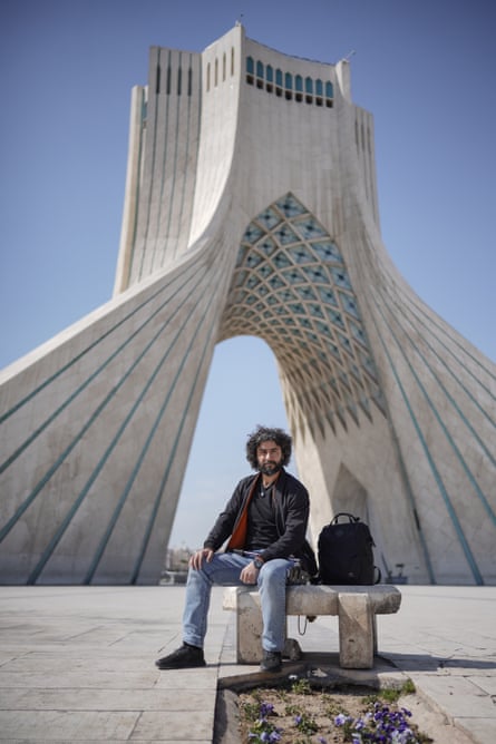 Ali, 36, sits on a bench with the Shayyad Tower behind him.