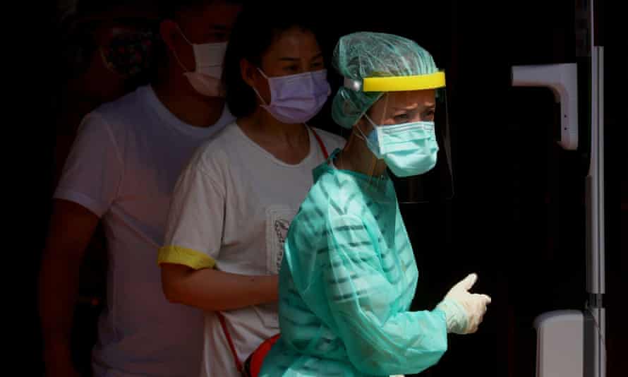 A healthcare worker prepares people for testing following a surge of covid 19 infections in Taipei.