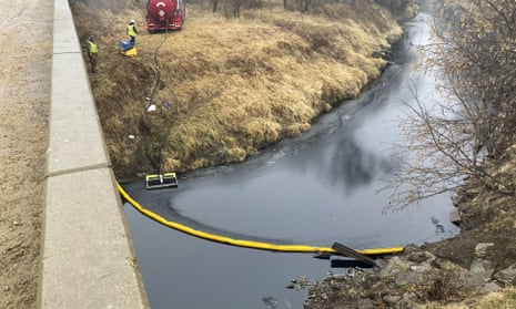 A remediation company deploys a boom on the surface of the oil spill.