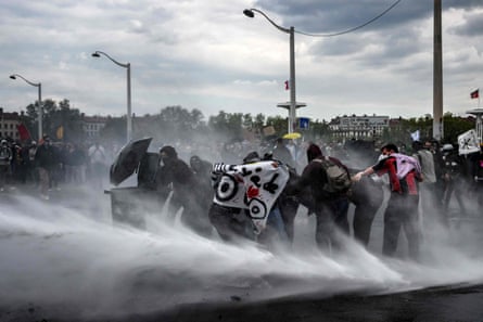 Manifestantes siendo rociados por un cañón de agua en Lyon.