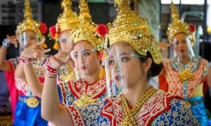 Traditional Thai dancers wearing protective face shields perform at the Erawan Shrine in Bangkok, which was reopened after the Thai government relaxed lockdown measures.