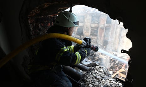 A firefighter sprays water from the rubble of the Culture Palace in Kharkiv, Ukraine, after a Russian strike
