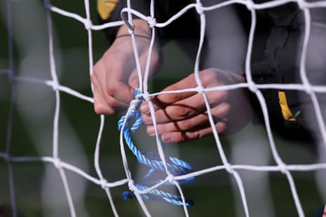 Groundstaff repair a hole in the goal net before the FA Cup fourth round match between Burton Albion and West Ham United.