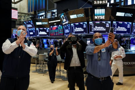 Workers celebrate the during closing bell on Friday, as they prepare for the return to trading, on the floor at the NYSE in New York.