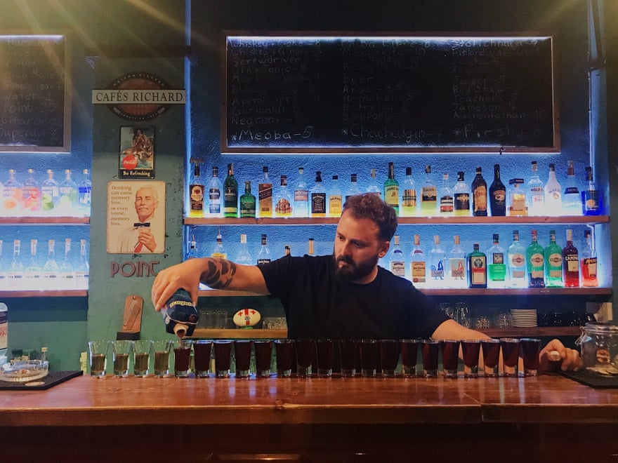 A barman pours drinks at Meoba bar