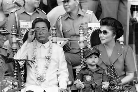 The Philippine president and first lady, Ferdinand and Imelda Marcos, observe college students undertaking compulsory military training in Manila, 1985.