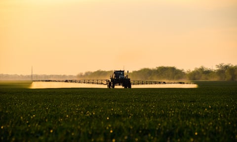 A tractor sprays chemicals on a field.