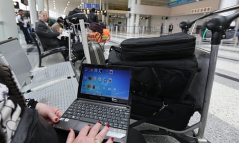 A woman travelling to the United States through Amman opens her laptop before checking in at Beirut international airport.
