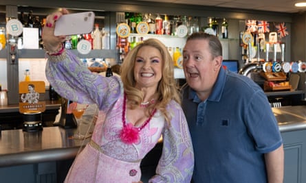 Sarah Hadland as Monica and Johnny Vegas as Terry grin cheesily into a phone camera for a selfie at the pub