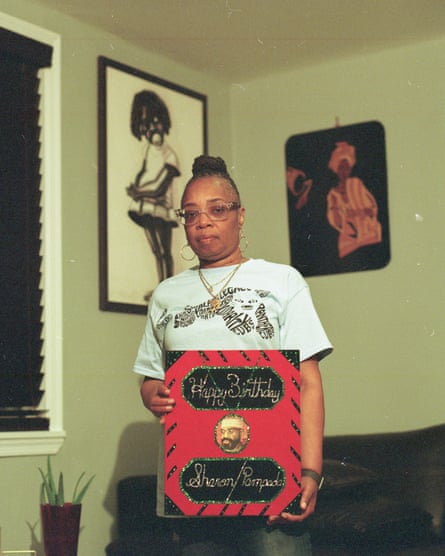 Portrait of Sharon Shoatz. She is holding a large decorated card that reads: ‘Happy birthday Sharon/Pampada’ and features a small picture of her father, Russell Shoatz