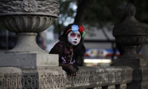A girl dressed as Catrina, the 'Lady of the Dead', leans against stone benches as she awaits the start of the Grand Procession of Catrinas in Mexico City, part of upcoming Day of the Dead celebrations. The figure of a skeleton wearing an elegant broad-brimmed hat was first done as a satirical engraving by artist Jose Guadalupe Posada sometime between 1910 and his death in 1913