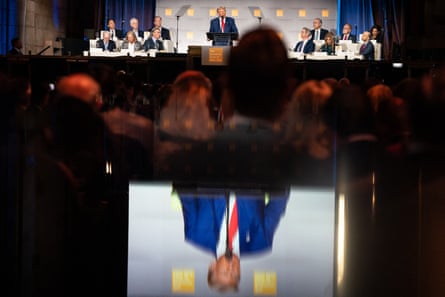a very rich man who lost the popular vote twice speaks to a crowd of people